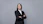 a woman in a business suit with her arms crossed