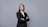 a woman in a business suit with her arms crossed
