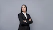 a woman in a business suit with her arms crossed
