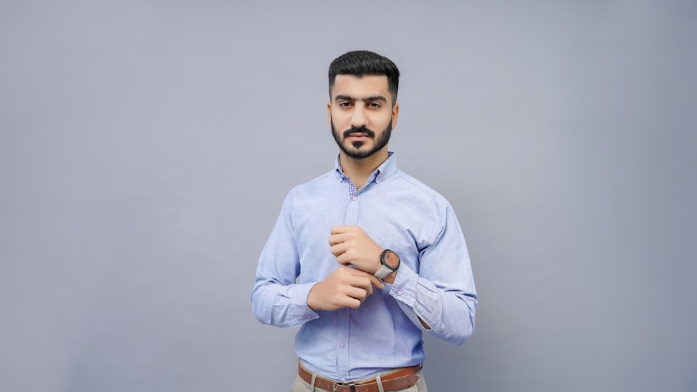 a man wearing a blue shirt and tan pants