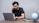 A person studying at a desk with a laptop and notes.