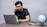 A person sitting at a desk, reviewing notes with a laptop open, focused on their interview preparation.