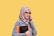 a woman in a hijab talking on a cell phone