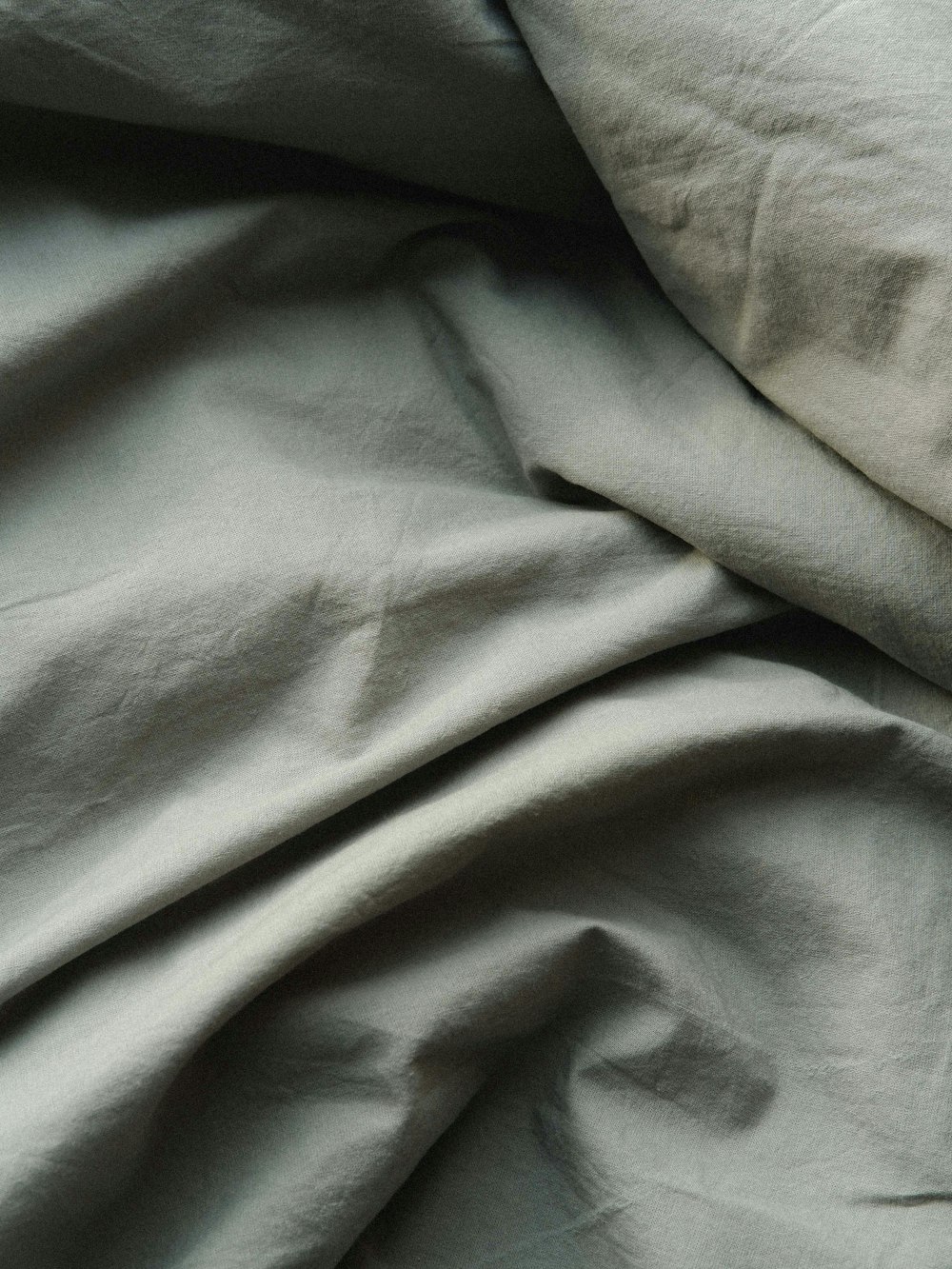 a close up of a bed with a white comforter