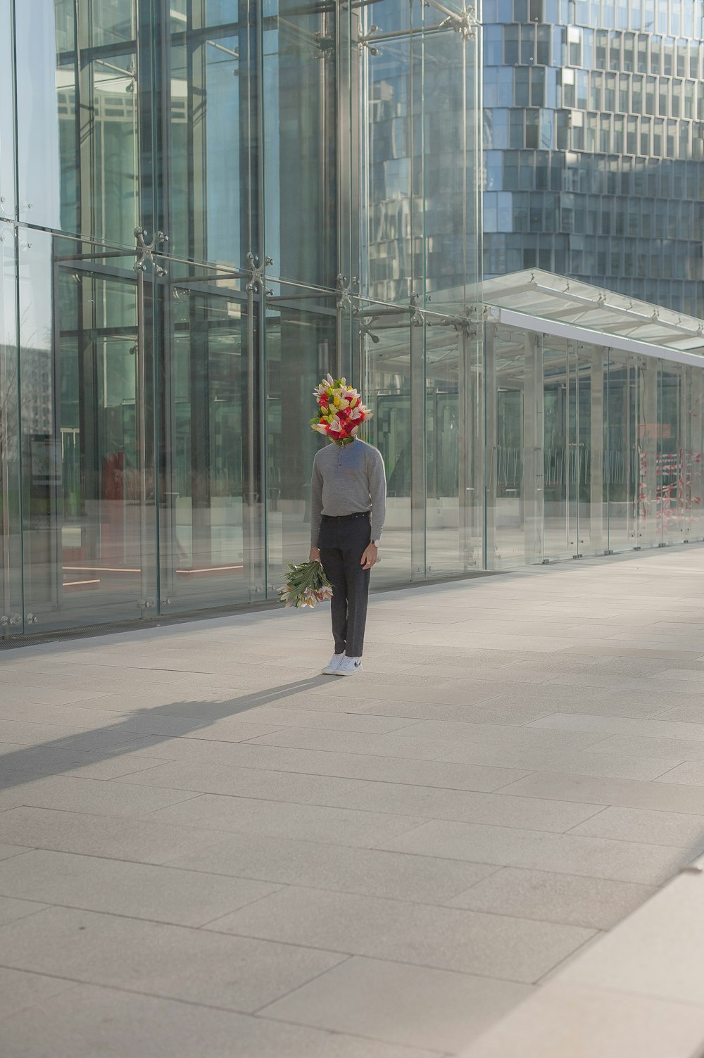 a person walking down a sidewalk with a bunch of flowers on their head