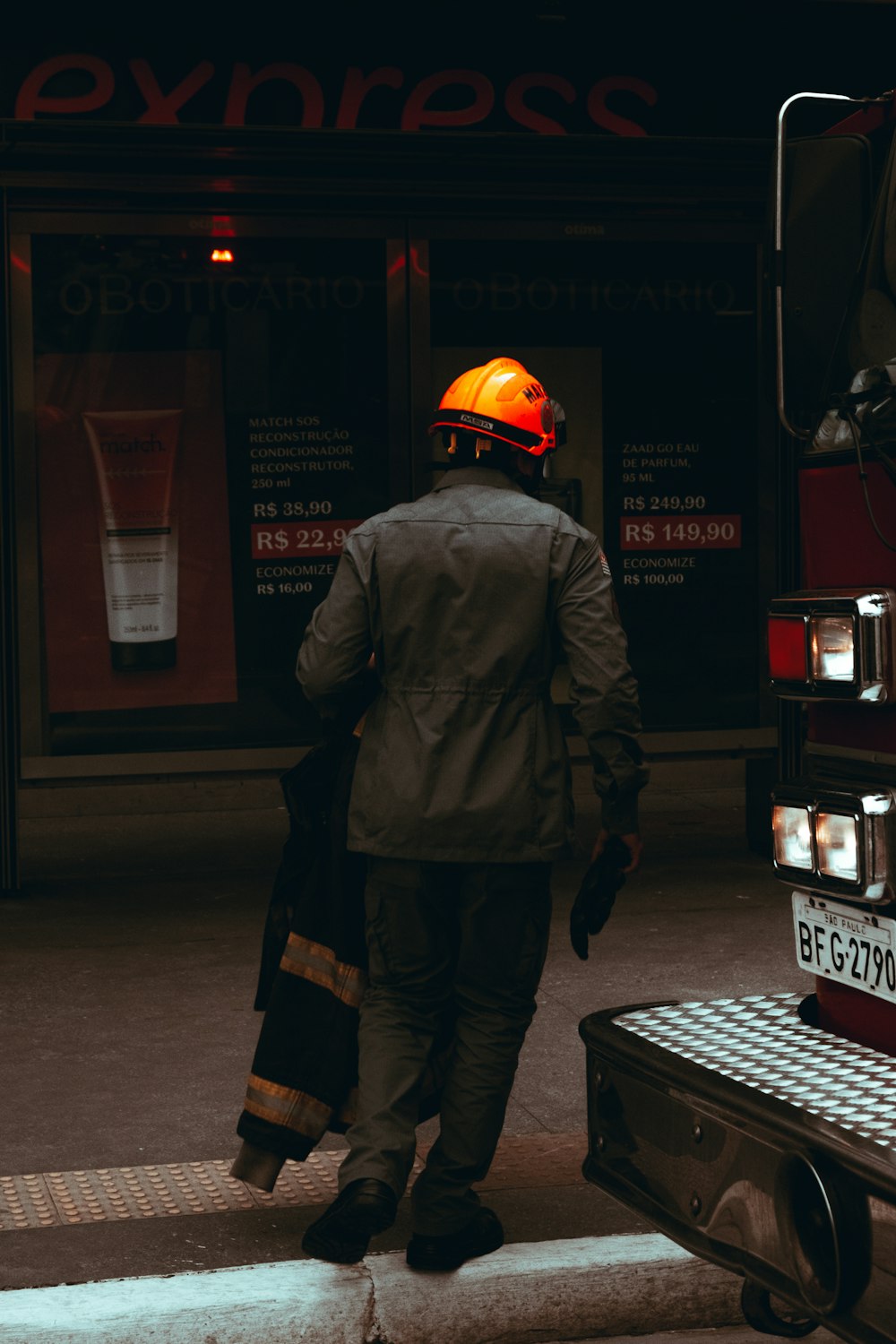 a man walking down a street next to a fire truck