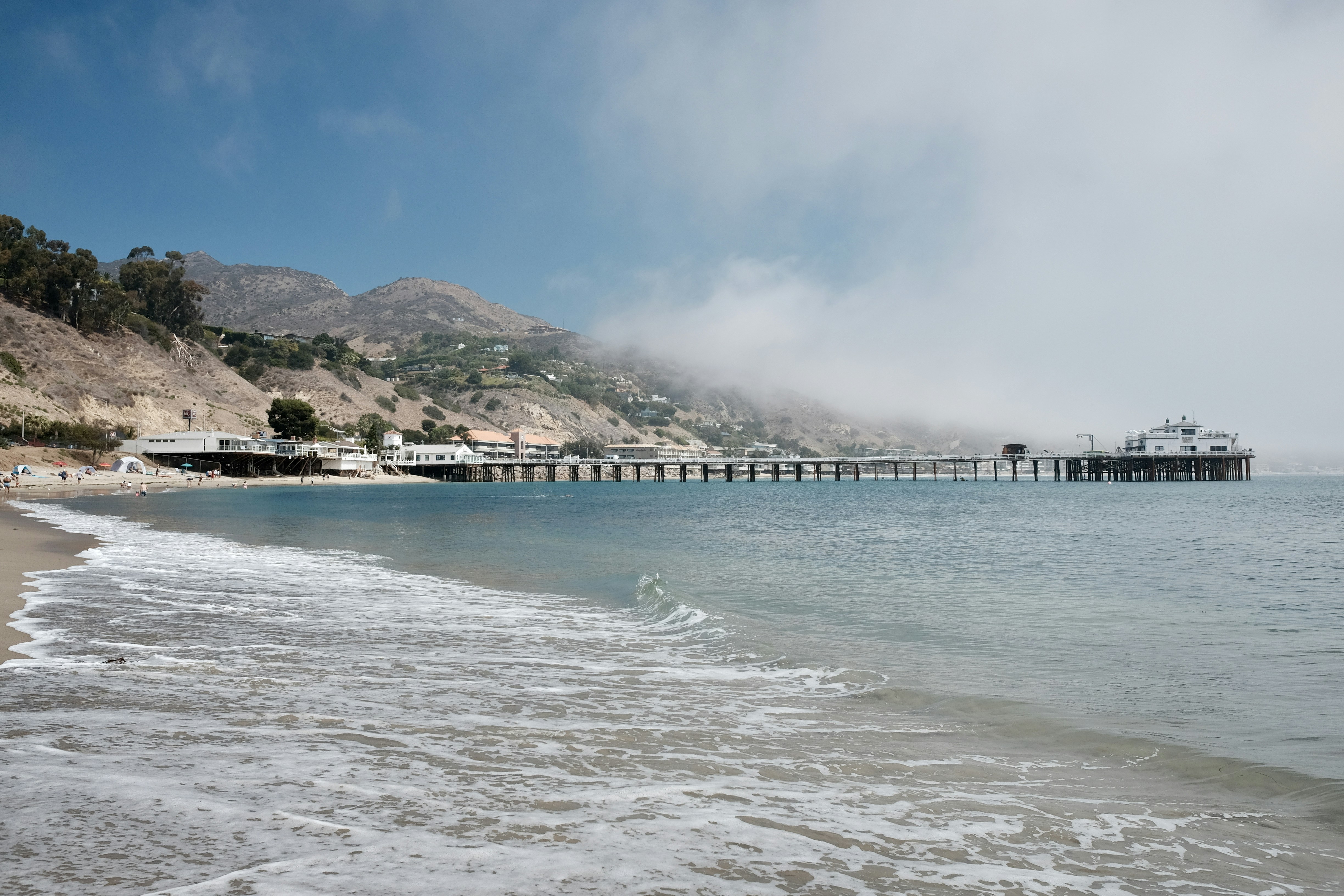 a beach with a pier in the background