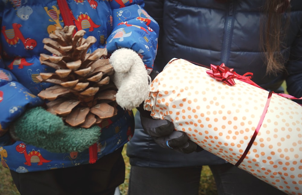 a couple of people holding a wrapped present