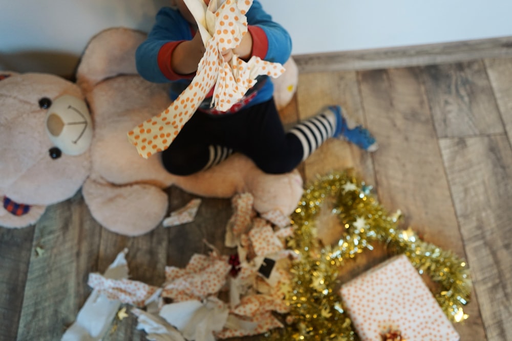 a teddy bear sitting next to a pile of presents