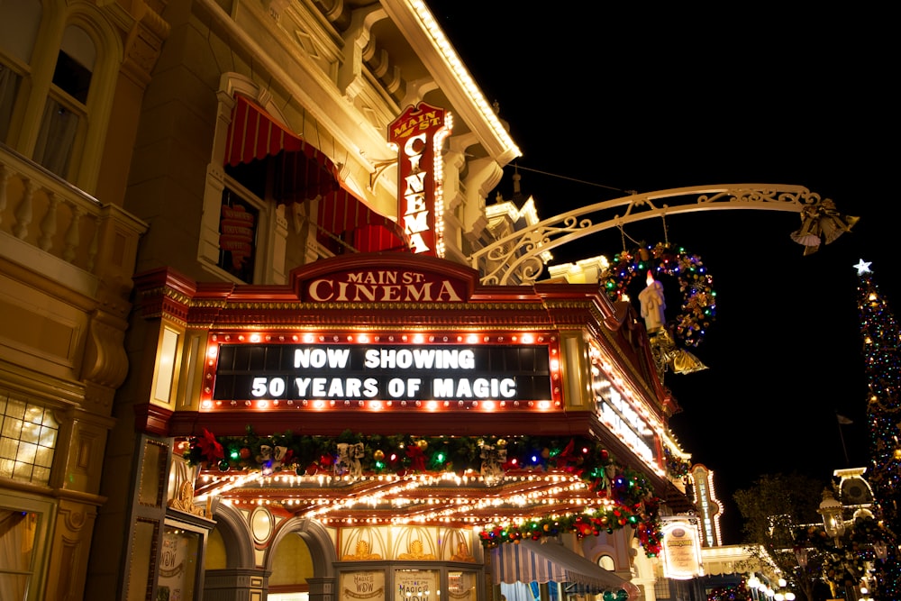 a theater marquee lit up at night with christmas lights