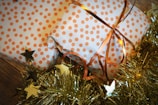 two wrapped presents sitting on top of a christmas tree