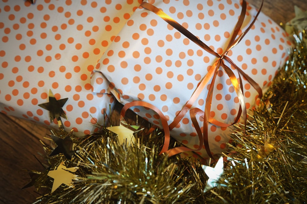 two wrapped presents sitting on top of a christmas tree