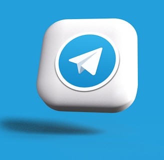 a blue and white square button with a paper airplane on it