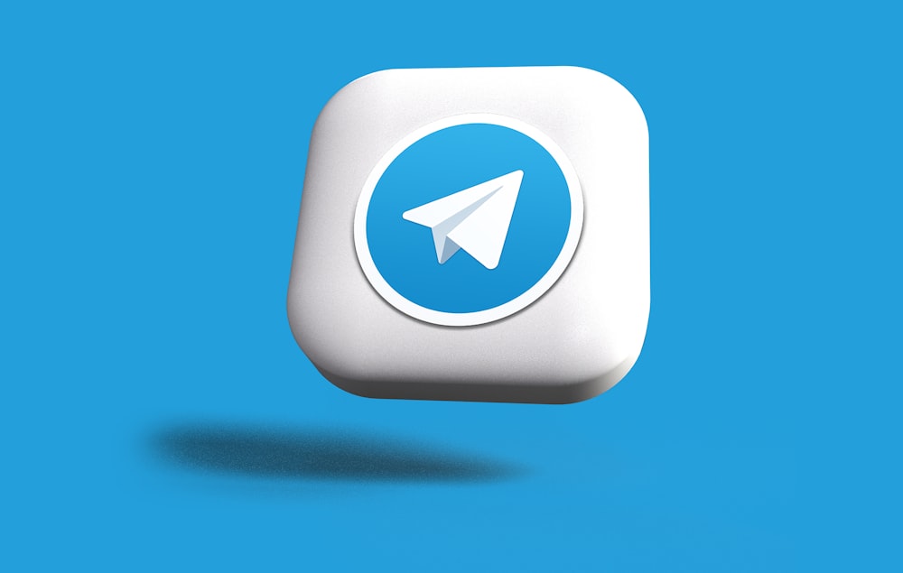 a blue and white square button with a paper airplane on it
