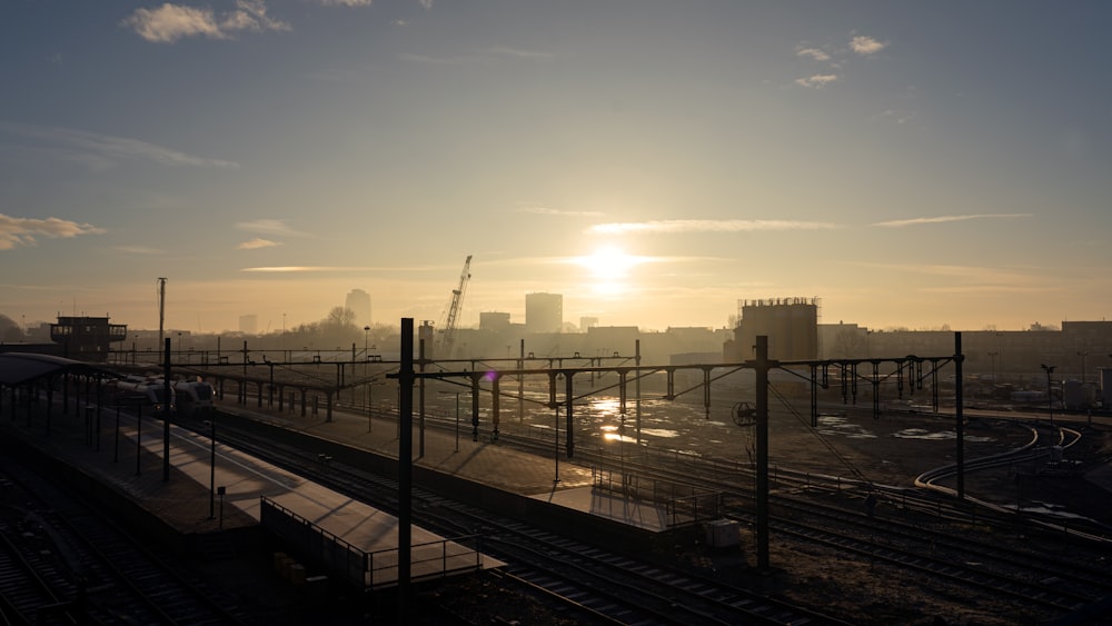 the sun is setting over a train track