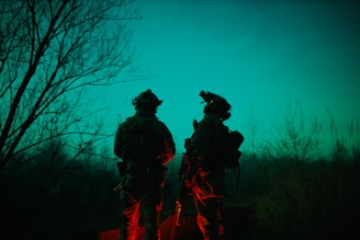 Team of operatives conducting a night navigation exercise in rugged terrain.