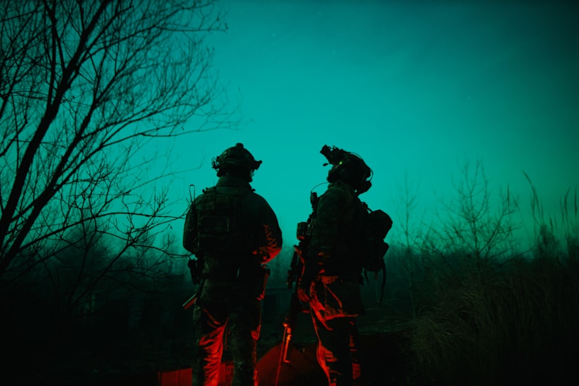 Ironforce Sentinel Compact unit deployed in a forested border area at dusk, showcasing its thermal vision capabilities.