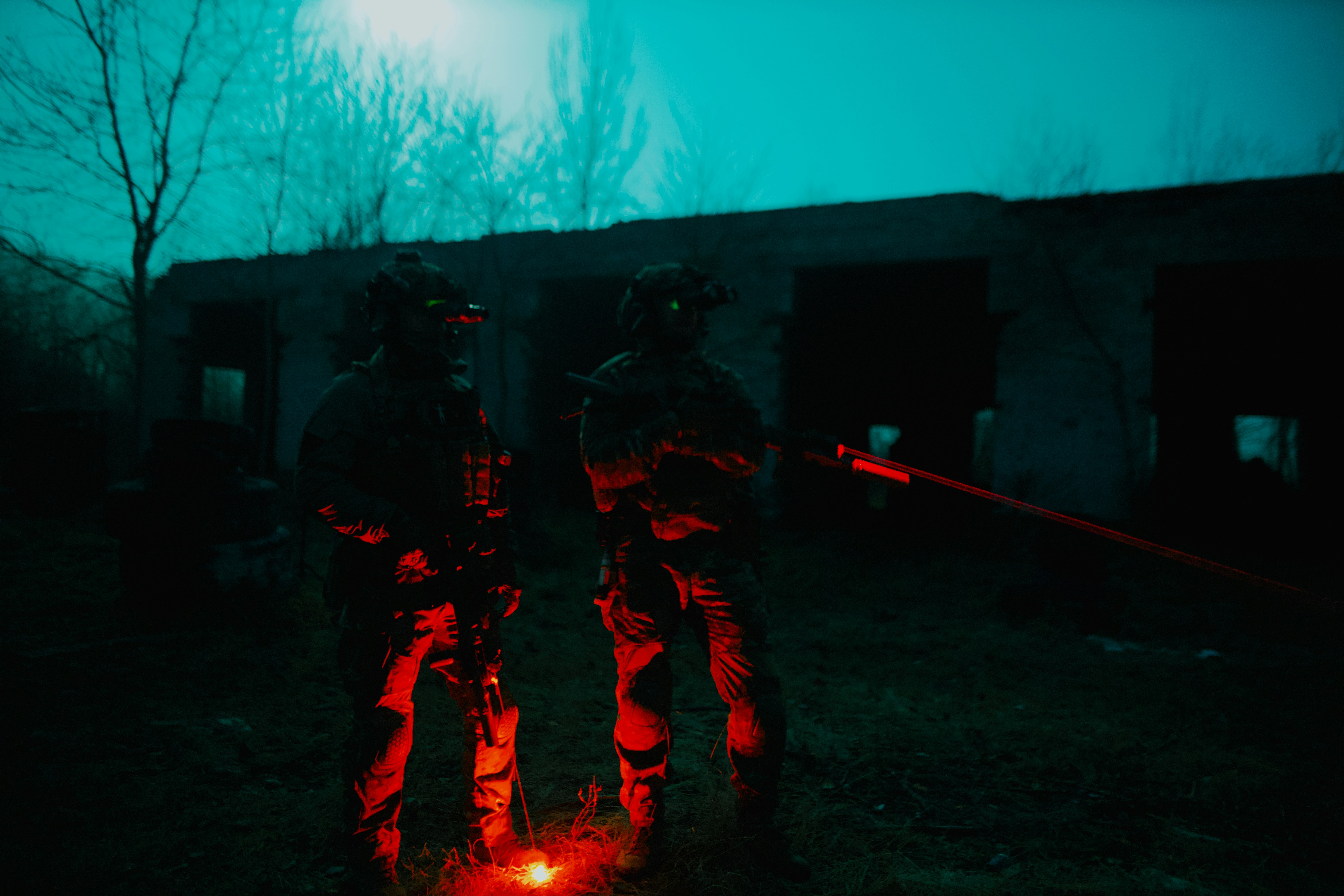 Tactical operators in dark military gear standing in formation at night, low key lighting, serious expressions, near-black background