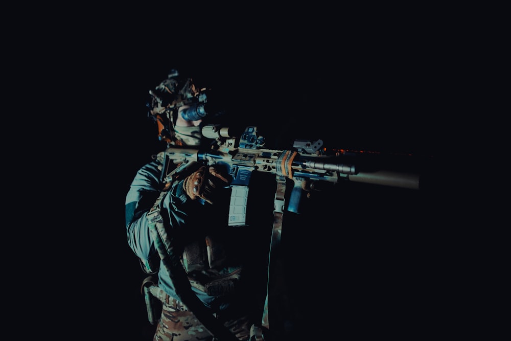 a man holding a rifle in the dark