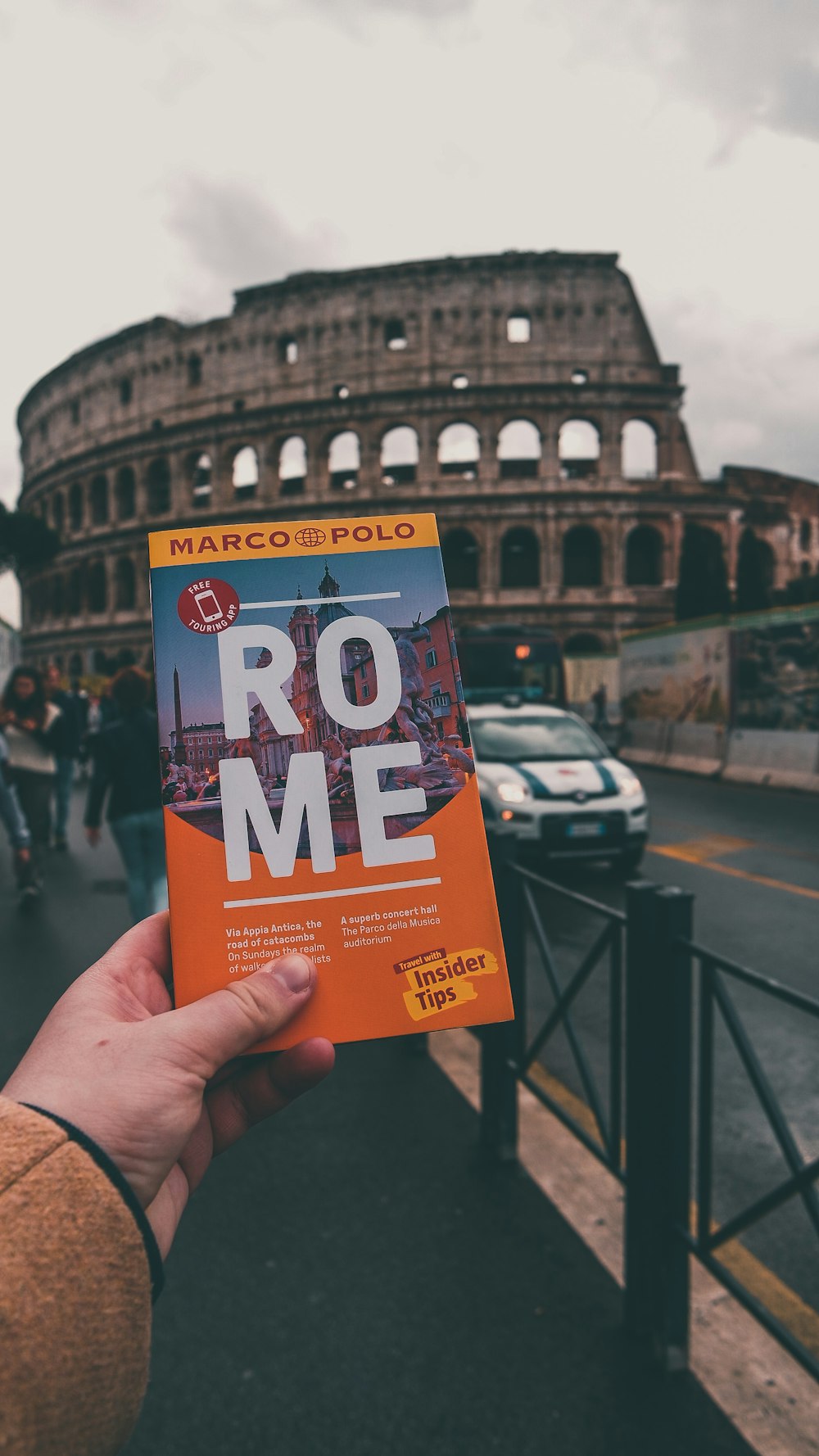 a person holding up a book in front of the colossion