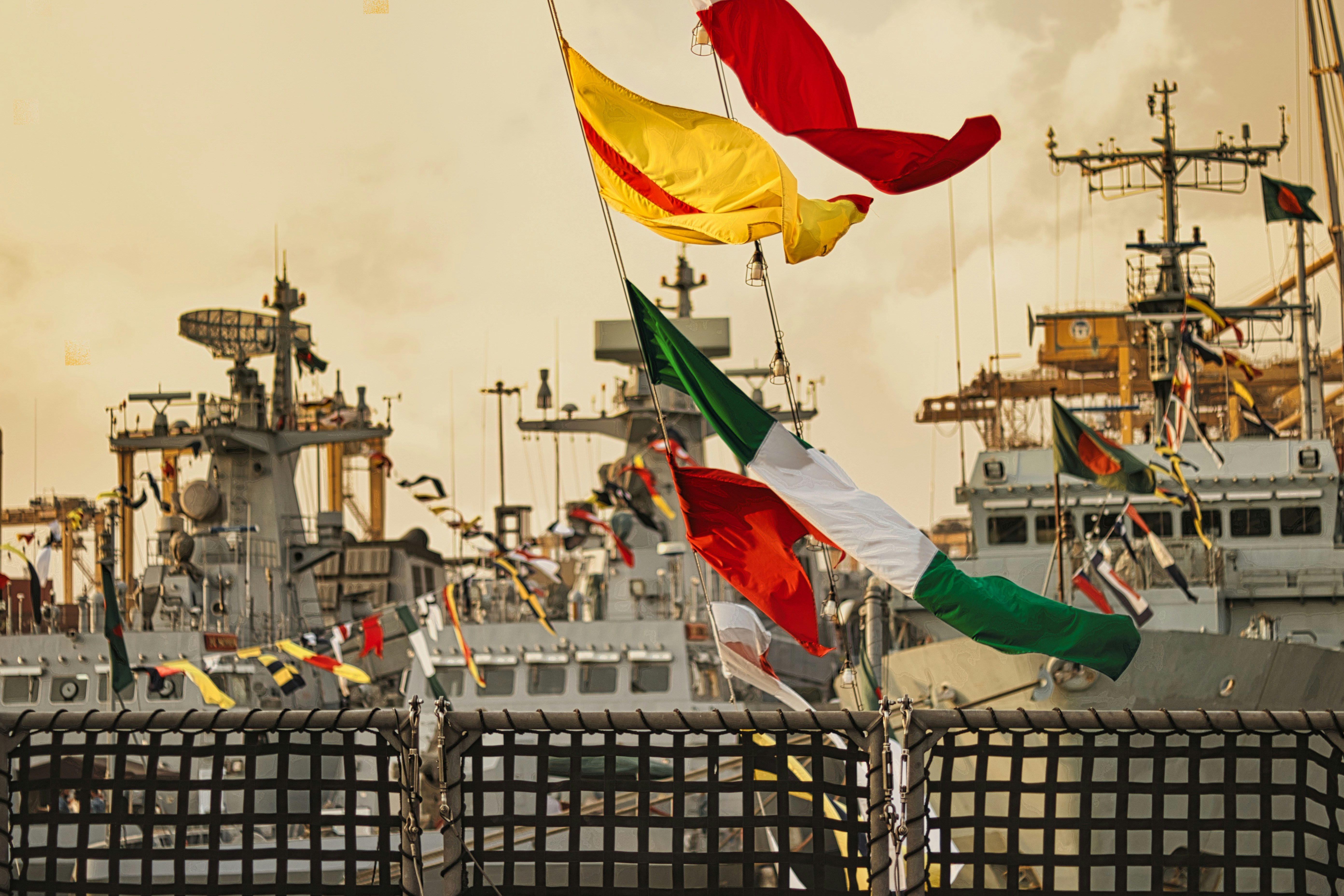 a group of flags flying in front of a ship