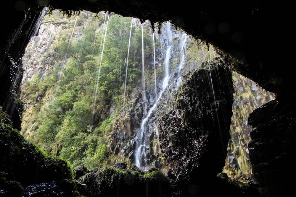 a view of a waterfall from inside a cave