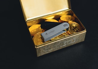 a swiss army knife sitting in a box of gold coins