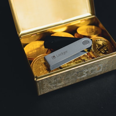 a swiss army knife sitting in a box of gold coins