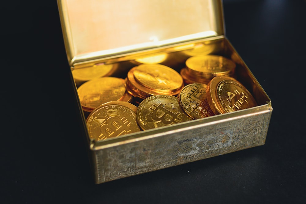 a box of gold coins sitting on a table