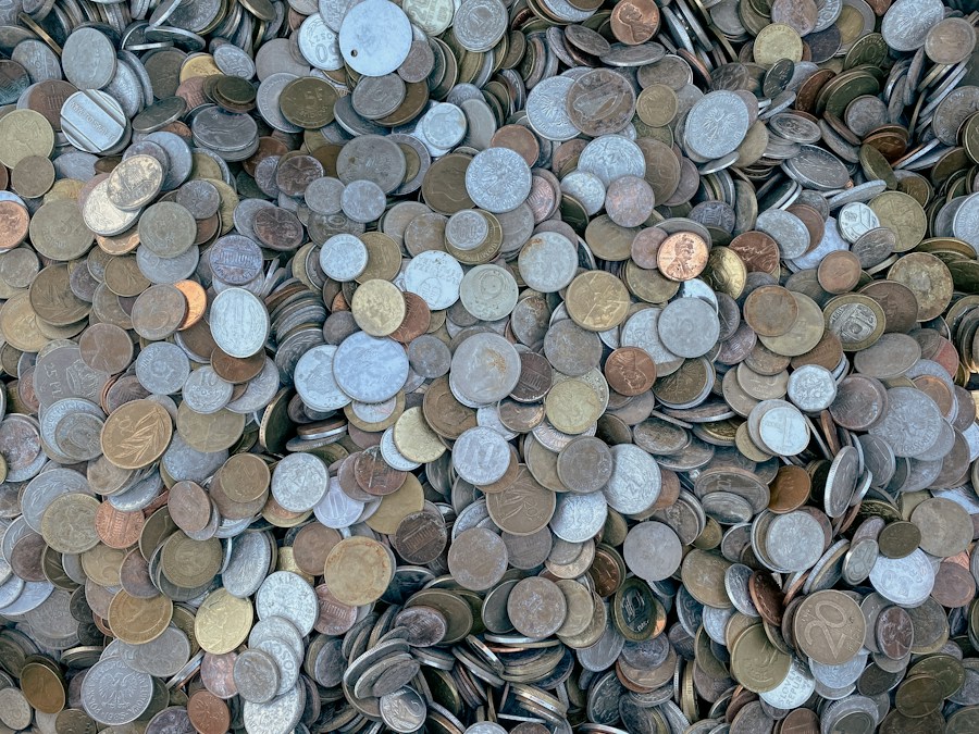 Un tas de pièces de monnaie usées, argentées et cuivrées, mélangées en vrac
