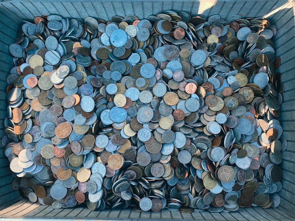 다양한 종류의 동전으로 가득 찬 쓰레기통