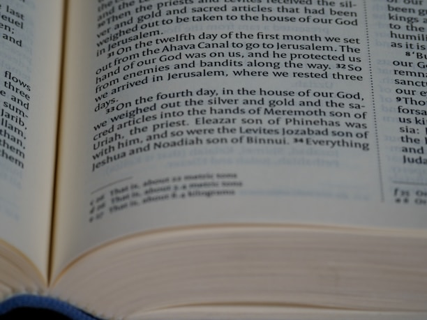 An open book with pages turning, symbolizing knowledge and tradition.