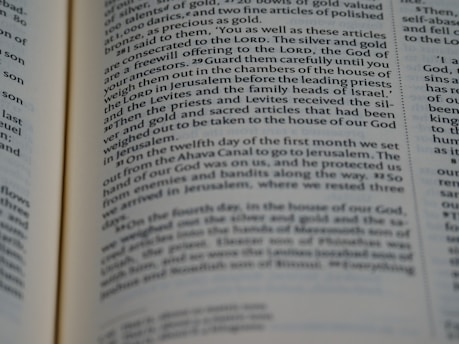 A close-up view of an open page from a book containing text that appears to be from a religious or historical text. The lines are in a serif font with certain words highlighted in bold, suggesting importance or emphasis.