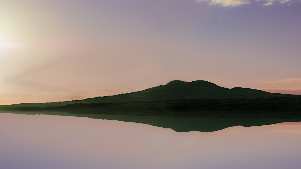 a large body of water with a mountain in the background