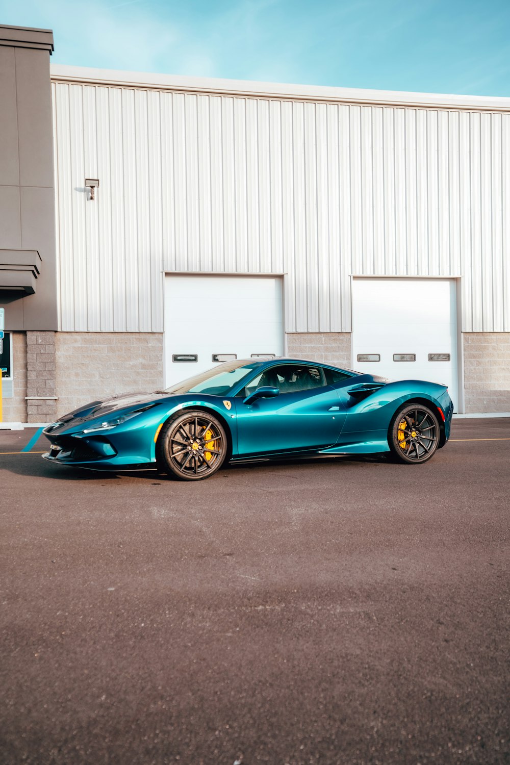 a blue sports car parked in front of a building