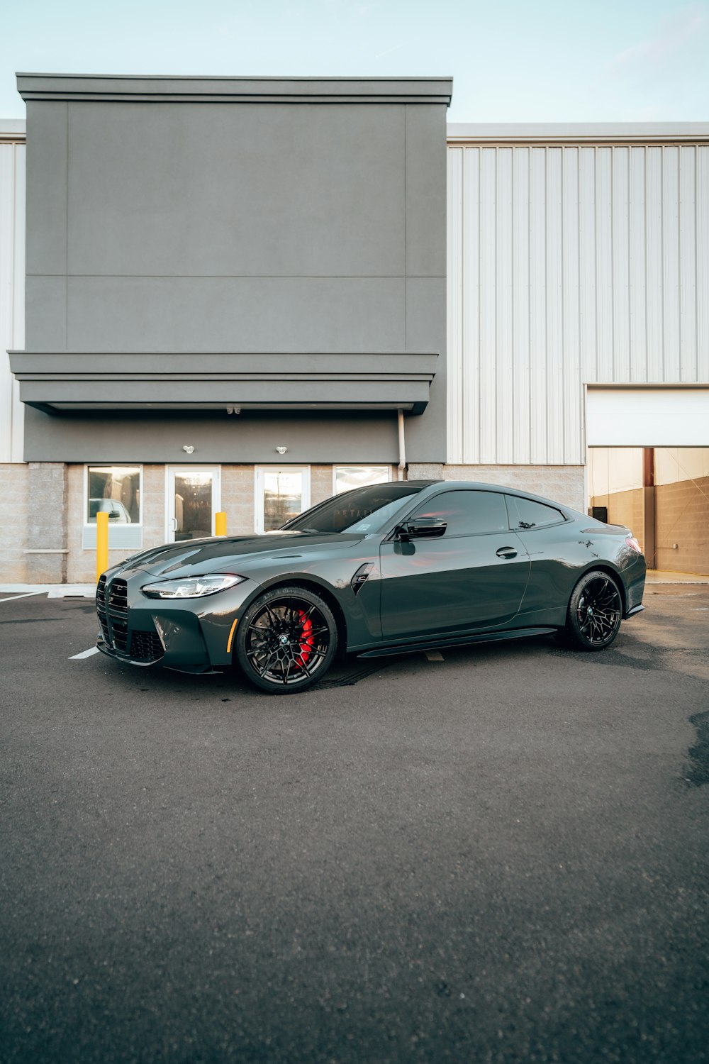 a grey sports car parked in front of a building