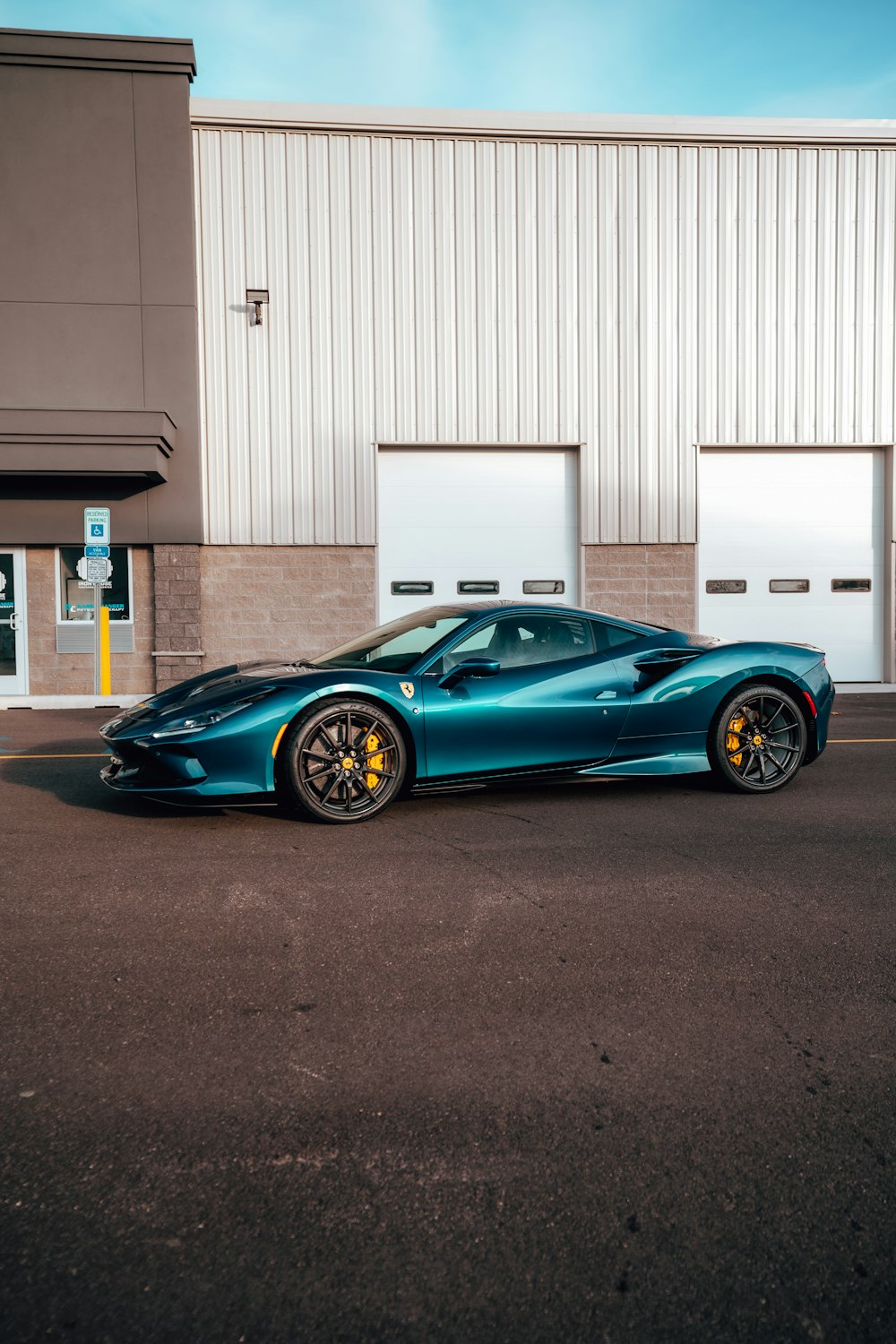 a blue sports car parked in front of a building