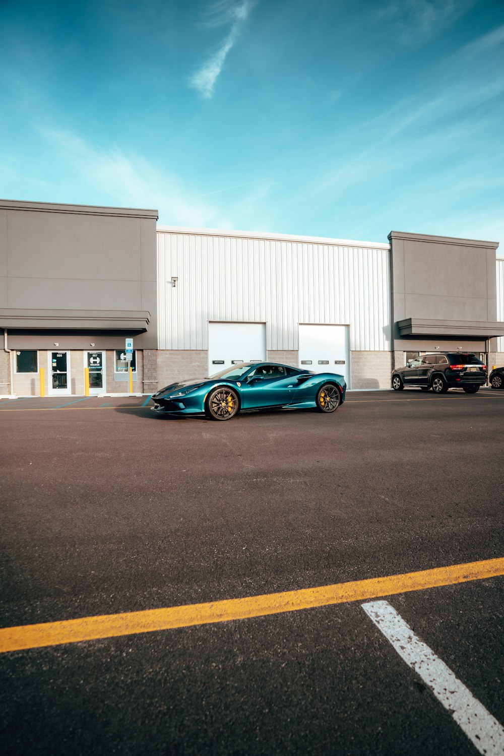 a blue sports car parked in front of a building