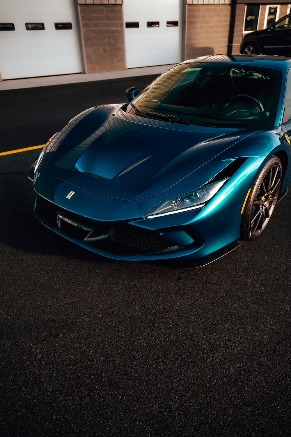 a blue sports car parked in front of a garage