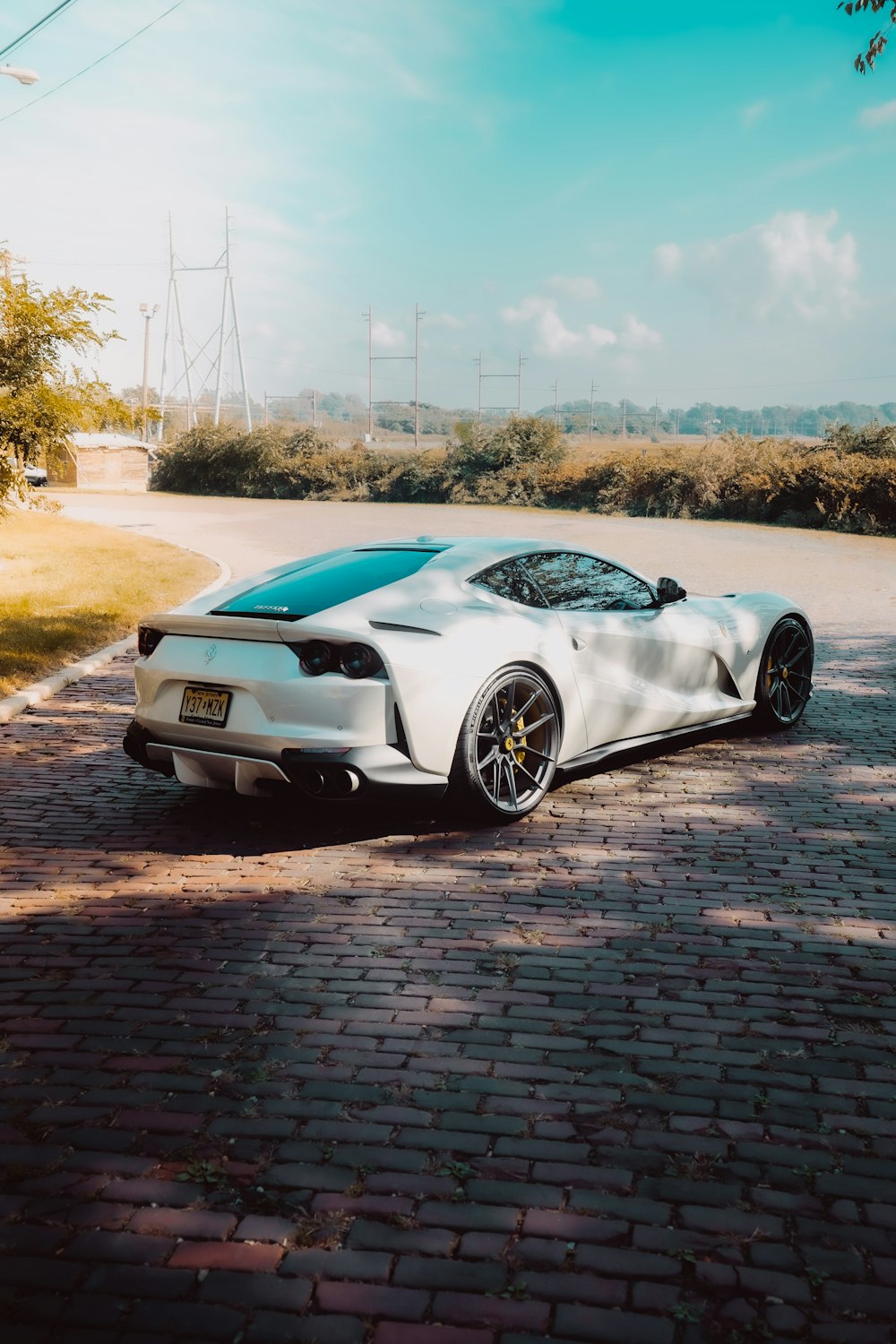 a white sports car parked on the side of a road