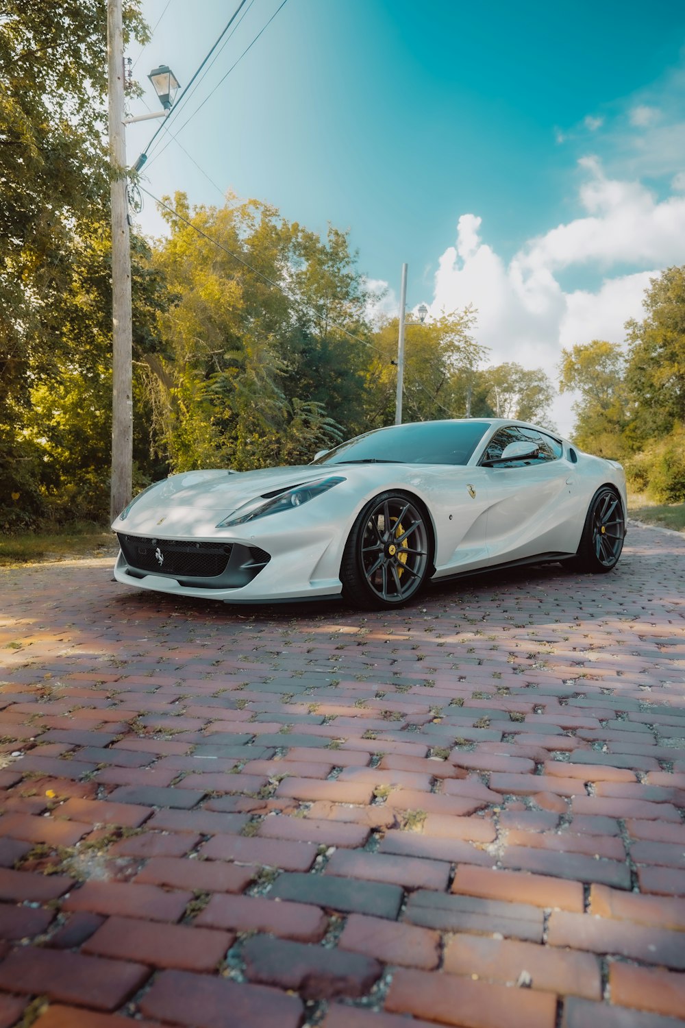 a white sports car parked on a brick road