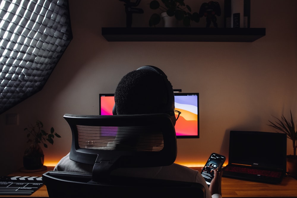 a person sitting at a desk in front of a computer