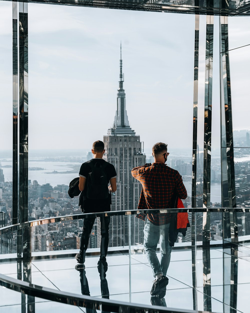 two men standing on top of a tall building