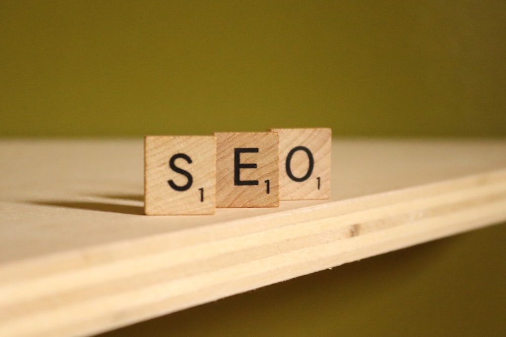 Tiles spelling the word "SEO" is displayed on a wooden shelf.
