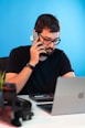 a man sitting at a desk talking on a cell phone