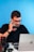 a man sitting at a desk talking on a cell phone