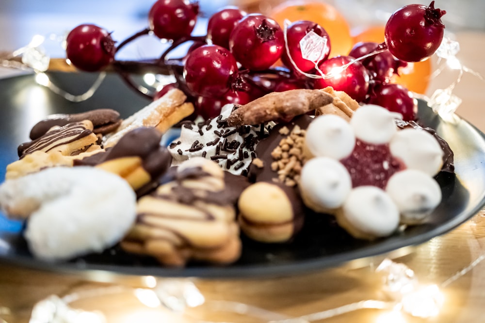 a plate of cookies, cookies, and cherries on a table