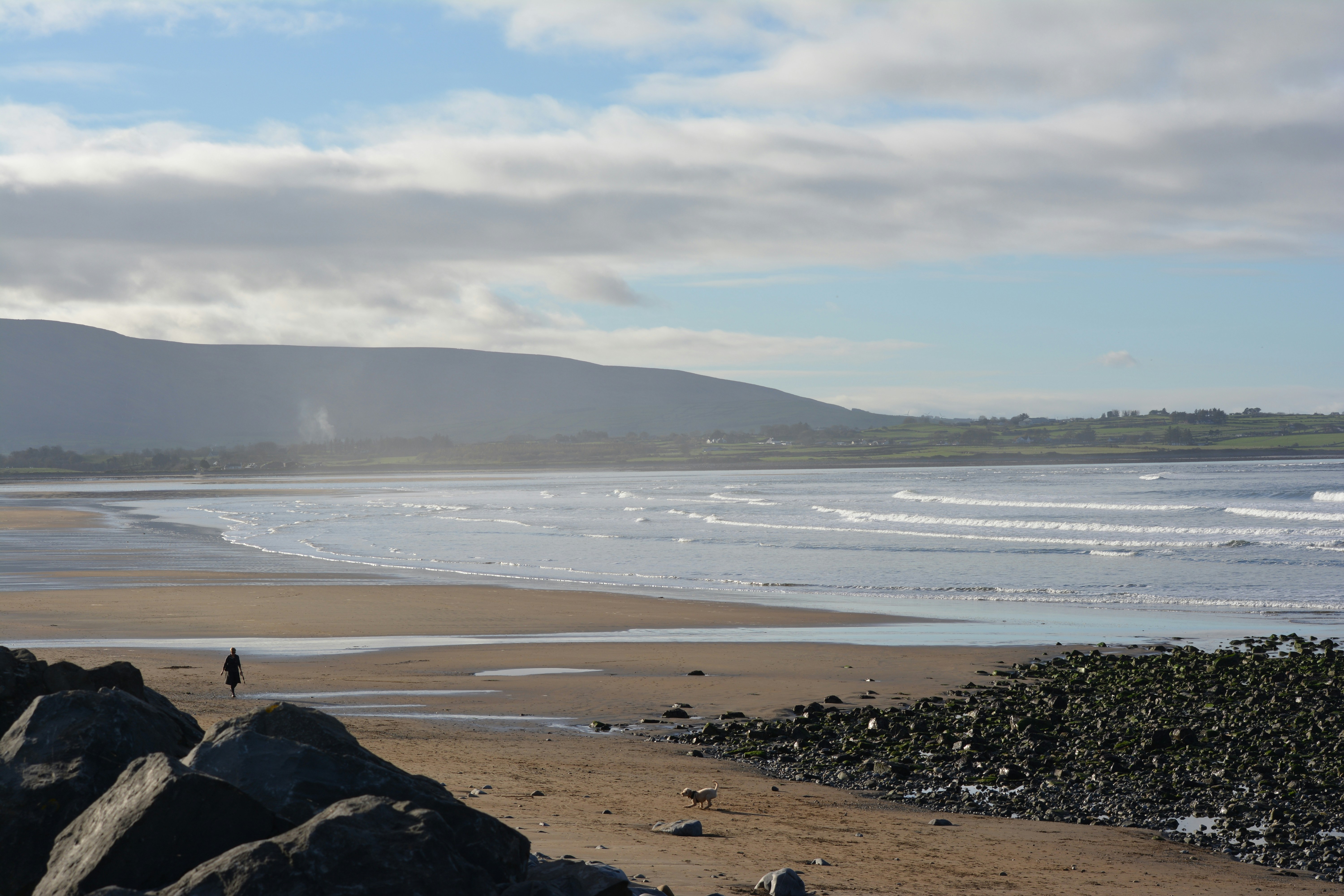 a person walking on a beach next to the ocean