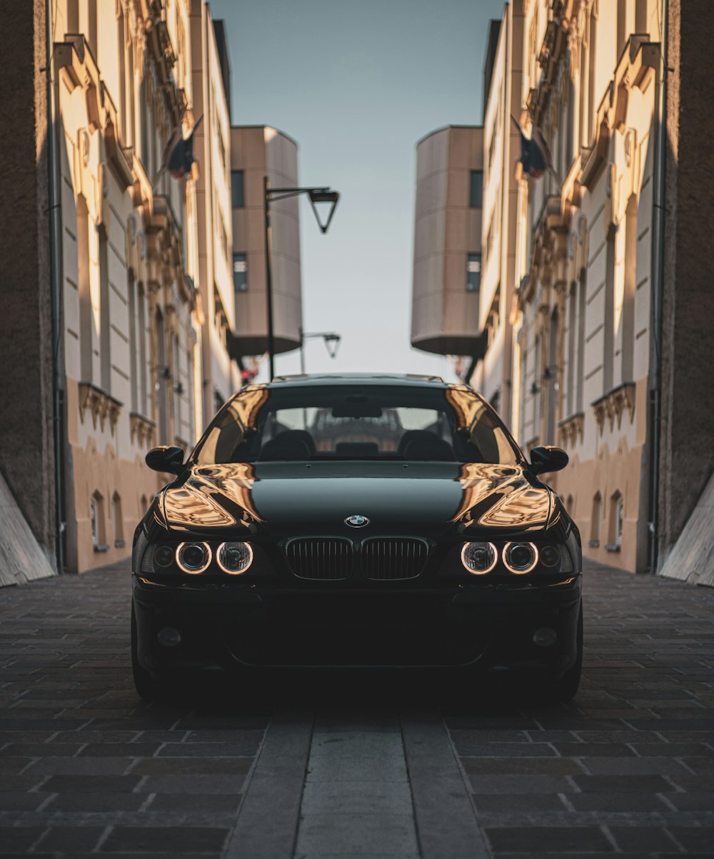 a black car parked in front of a tall building