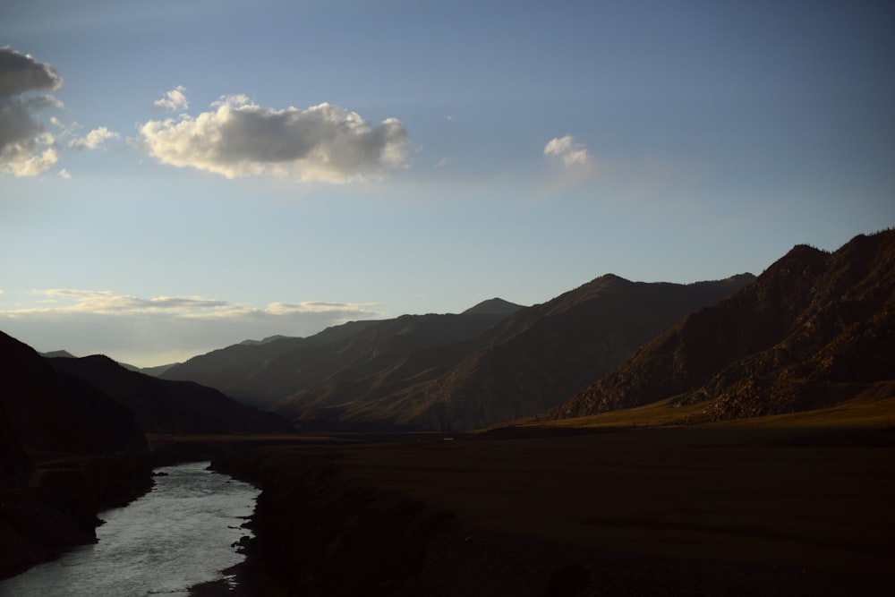 a river running through a valley surrounded by mountains